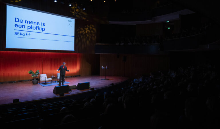 Teun van de Keulen staat op het podium tijdens zijn theateravond 'De mens is een plofkip'.