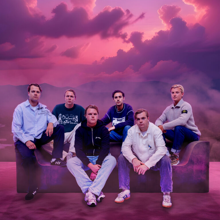De zeven jongens van Turfy Gang zitten op een bank. In de achtergrond is een lucht met wolken te zien die paars en roze gekleurd is.