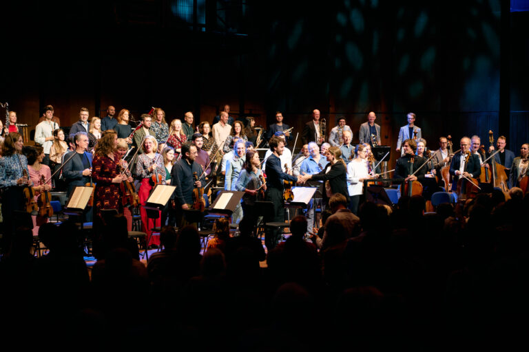 Staande ovatie voor het orkest dat op het podium staat