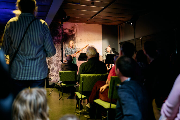 Orkest lid (fagot) die aan het vertellen is voor een groep mensen
