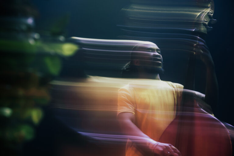 Een muzikant die een contrabas bespeelt, weergegeven in een dynamische en onscherpe stijl.