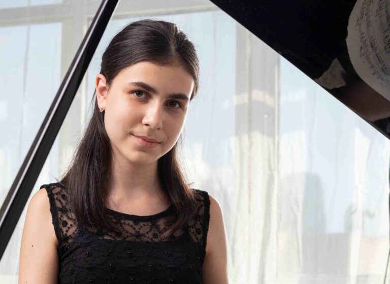 Alexandra Dovgan staand voor de vleugel met muziekboek in haar hand
