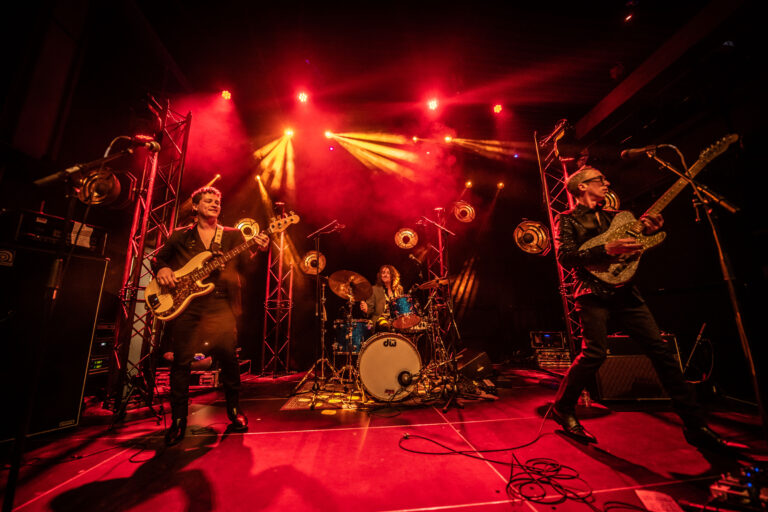 Een band treedt op met felgekleurde lichten en energie op het podium.