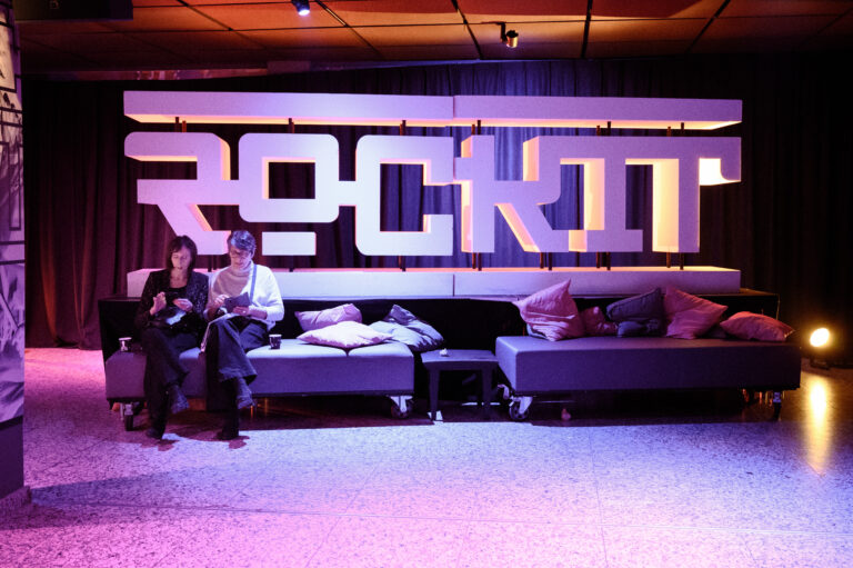 Een moderne lounge met een groot verlicht bord waarop