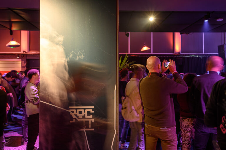 Een drukke bijeenkomst met mensen die samenkomen in een sfeervol verlichte ruimte.