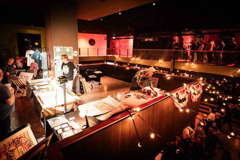 Een levendige marktsetting met meerdere verkoopstandjes en bezoekers in een sfeervol verlichte ruimte.