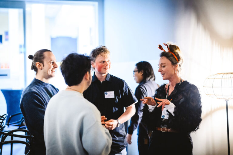 Een groep mensen staat in gesprek in een lichte, moderne ruimte.