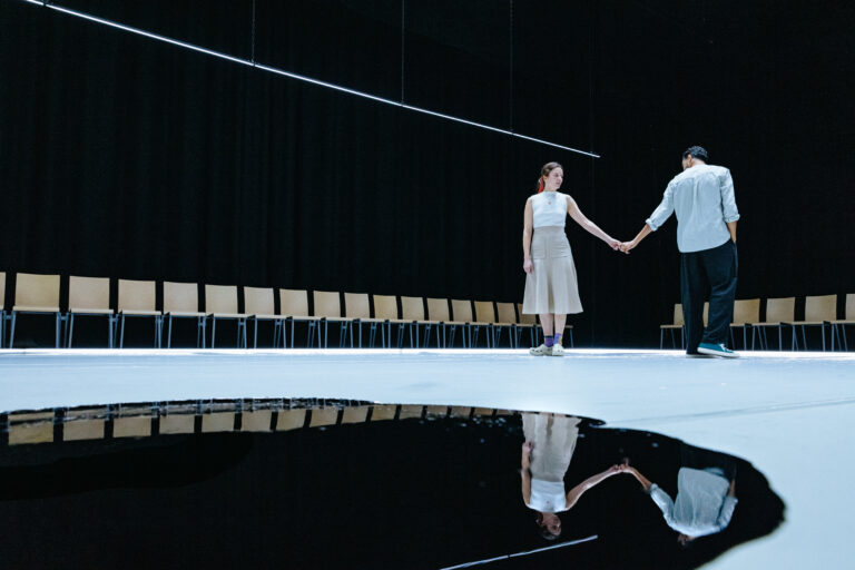 man en vrouw die handen vasthouden naast plas zwart water