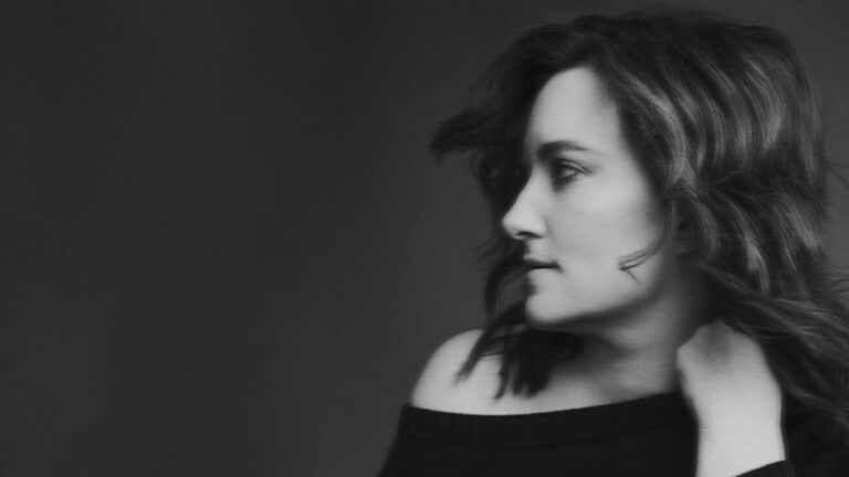 Zwart-wit portret van een vrouw in profiel, met losse haren en een ontspannen houding.