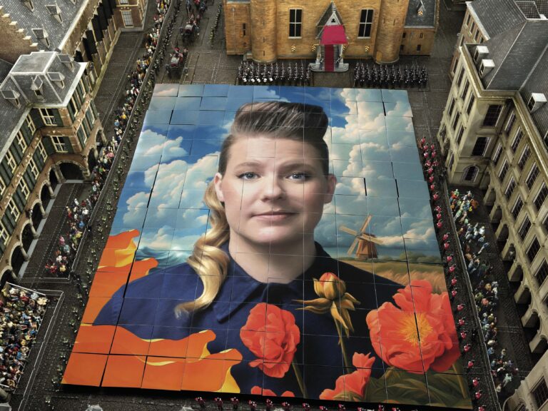 Grote muurschildering van een vrouwelijk portret met een kleurrijke achtergrond en rode rozen.