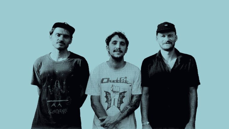 Drie mannen poseren samen voor een turquoise achtergrond.