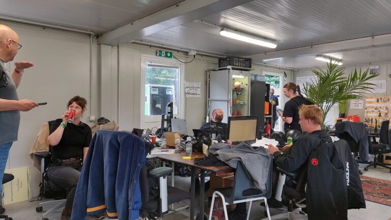 Container op terrein Summerstage met drukke medewerkers die aan het overleggen en regelen zijn.