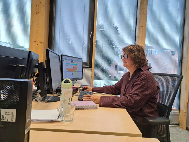 Sarina AB achter een bureau.