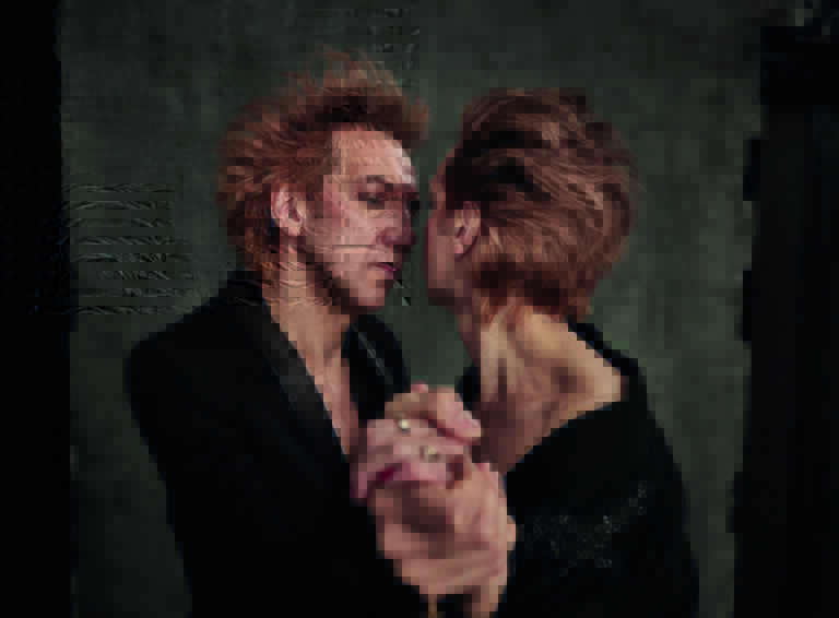 Twee personen staan dicht bij elkaar en lijken elkaar aan te kijken.