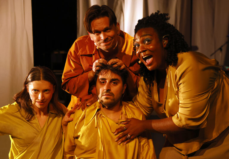 4 personen, degene in het midden kijkt bezorgd, de andere blij.