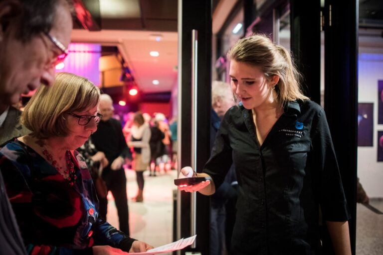 mevrouw die een ticket laat scannen bij de medewerker