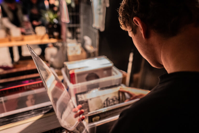 Man bladerend door een stapel platen.