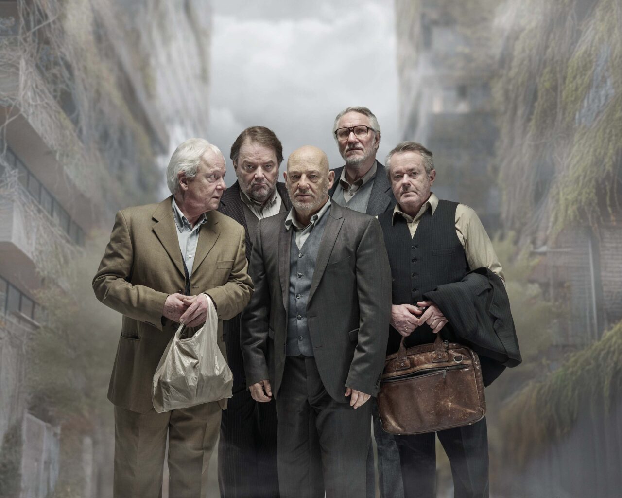 Een groep mannen in nette kleding poseert voor een grote waterval op de achtergrond.