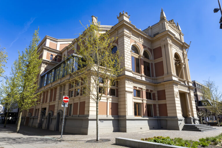 Stadsschouwburg met blauwe lucht met bomen