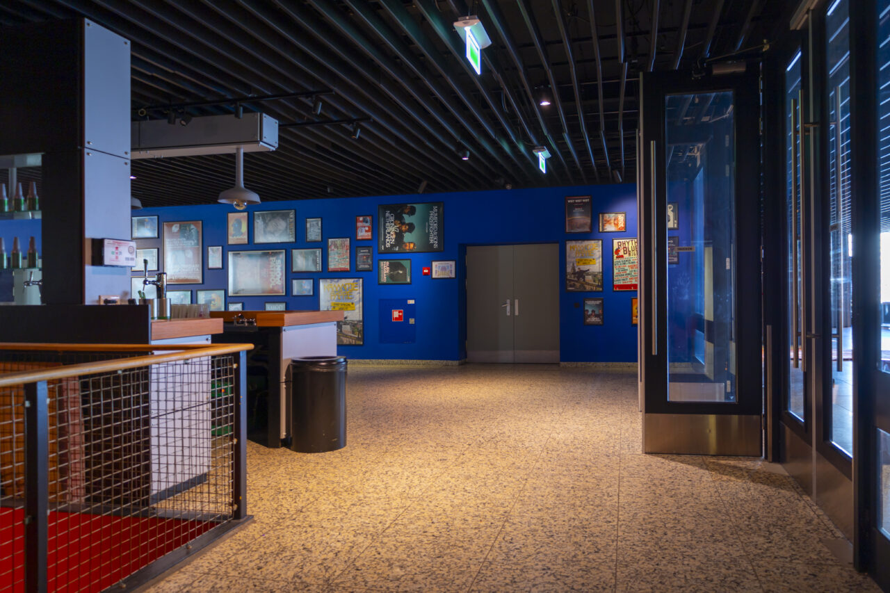 Blauwe muur met posters en een grote deur
